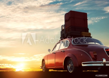 Bild på Retro red car with luggage on roof rack at sunset Travel vacation concepts